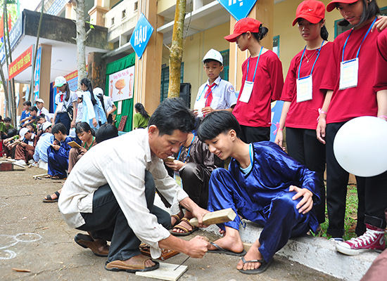 Học sinh Trường THCS Lương Thế Vinh (xã Tam Thành, Phú Ninh) trải nghiệm công đoạn nghề mộc với thợ mộc đến từ làng mộc Vân Hà. Ảnh: V.A